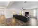 Spacious living room with modern decor, neutral color palette, ceiling fan, and tile flooring at 2213 N Park Meadows Dr, Buckeye, AZ 85396