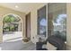 Inviting covered porch with a welcome mat, accent chair and a large window for natural light at 2213 N Park Meadows Dr, Buckeye, AZ 85396