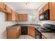 Kitchen featuring wood cabinets, black appliances, and laminate countertops at 2311 E Hartford Ave # 29, Phoenix, AZ 85022