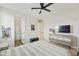 Bright bedroom with light gray decor, ceiling fan, and a TV on the dresser at 2501 S Roanoke St, Gilbert, AZ 85295