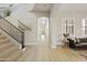 Bright foyer with a stairway, dark metal railing, wood flooring, and a view down the hallway at 2501 S Roanoke St, Gilbert, AZ 85295