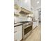 Modern kitchen with stainless steel appliances, white cabinetry, and stylish floating shelves at 2501 S Roanoke St, Gilbert, AZ 85295