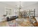 Comfortable living room features a sofa, chandelier, area rug, and built in shelving near the windows at 2501 S Roanoke St, Gilbert, AZ 85295