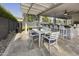 Under-the-pergola patio with an outdoor kitchen, dining table, and seating area at 2501 S Roanoke St, Gilbert, AZ 85295