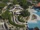 A high angle view of winding waterslides adjacent to a community swimming pool surrounded by greenery at 2512 E Katrina Trl, Casa Grande, AZ 85194