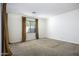 An empty bedroom has a window with curtains, carpet flooring and neutral colored walls at 2512 E Katrina Trl, Casa Grande, AZ 85194