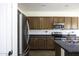 A view of the kitchen featuring stainless steel appliances, tile backsplash, and dark countertops at 2512 E Katrina Trl, Casa Grande, AZ 85194