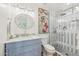 Stylish bathroom featuring a glass-enclosed shower with striped tile and a blue vanity with marble countertop at 2625 N 24Th St # 15, Mesa, AZ 85213