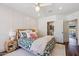 Cozy bedroom features a decorative bed, ceiling fan, paneled wall and light wood floors at 2625 N 24Th St # 15, Mesa, AZ 85213