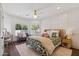 Well-lit bedroom with decorative bed, gray settee, dark wood floors and paneled accent wall at 2625 N 24Th St # 15, Mesa, AZ 85213