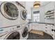 Bright laundry room has stacked washer/dryers, a window, white cabinets and black countertop at 2625 N 24Th St # 15, Mesa, AZ 85213