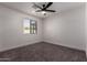This bedroom features neutral colored walls, carpet, and a black ceiling fan at 313 N 101St Way, Mesa, AZ 85207