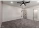 This bedroom features gray carpet, light gray walls, and access to another room at 313 N 101St Way, Mesa, AZ 85207