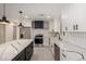 Modern kitchen boasts white cabinets, a black island with marble countertop, and stainless steel appliances at 313 N 101St Way, Mesa, AZ 85207