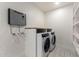 This laundry room includes modern washer and dryer units, and built-in storage and shelving at 313 N 101St Way, Mesa, AZ 85207