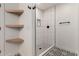 This shower offers a black and white tile design, built-in niche, and wooden shelves at 313 N 101St Way, Mesa, AZ 85207