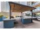 Outdoor kitchen and entertainment area with a built-in grill, bar seating, and a pergola for shade at 3131 N Central Ave # 3004, Phoenix, AZ 85012