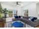 Bright living room with hardwood floors, gray sectional sofa, ceiling fan, and large lattice windows at 3204 N Jay St, Chandler, AZ 85225