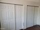 Bedroom closet featuring large white sliding doors and wood laminate flooring at 3810 N Maryvale Pkwy # 2077, Phoenix, AZ 85031