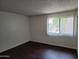 Bedroom featuring dark wood floors and a window with privacy blinds at 3810 N Maryvale Pkwy # 2077, Phoenix, AZ 85031
