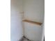 Small, unfinished closet featuring cinder block walls and a single wood shelf for storage at 3810 N Maryvale Pkwy # 2077, Phoenix, AZ 85031