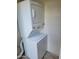 Laundry area with stacked washer and dryer set and concrete block walls at 3810 N Maryvale Pkwy # 2077, Phoenix, AZ 85031