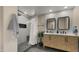 Elegant bathroom with a walk-in shower, dual vanities, herringbone cabinetry, and modern fixtures at 4040 E Becker Ln, Phoenix, AZ 85028