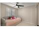 Cozy bedroom with a twin bed, plush bedding, and bright natural light filtering through the shuttered window at 4040 E Becker Ln, Phoenix, AZ 85028
