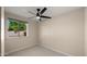 Bright, empty bedroom with a ceiling fan, neutral walls, and a view of the backyard through a window at 4040 E Becker Ln, Phoenix, AZ 85028