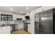Updated kitchen with stainless steel appliances, white cabinetry, and a large refrigerator at 4040 E Becker Ln, Phoenix, AZ 85028