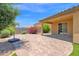 Landscaped backyard featuring an extended covered patio and a brick paver section at 40479 W Marion May Ln, Maricopa, AZ 85138