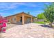 Private backyard with a covered patio, mature trees, and a brick paver area at 40479 W Marion May Ln, Maricopa, AZ 85138