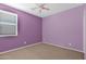 A pink room with a window and neutral-toned carpet flooring, offering a bright living space at 40479 W Marion May Ln, Maricopa, AZ 85138