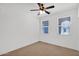 A bright, unfurnished bedroom with neutral carpet and two bright, natural light-filled windows at 40479 W Marion May Ln, Maricopa, AZ 85138
