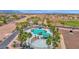 Aerial view of community pool featuring mature palm trees, splash pad, and seating at 40479 W Marion May Ln, Maricopa, AZ 85138
