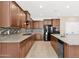 A spacious kitchen featuring granite countertops, stainless steel appliances, and wood cabinets at 40479 W Marion May Ln, Maricopa, AZ 85138