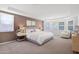 A furnished and comfortable main bedroom featuring large bay windows for natural light at 40479 W Marion May Ln, Maricopa, AZ 85138