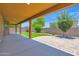 An oversized covered patio with lush green landscaping at 40479 W Marion May Ln, Maricopa, AZ 85138