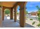 Covered porch featuring elegant columns and views of the landscaped front yard and neighborhood at 40479 W Marion May Ln, Maricopa, AZ 85138