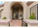 Inviting front porch area featuring a covered entryway, decorative door, seating, and desert landscaping at 40614 N Harbour Town Ct, Anthem, AZ 85086