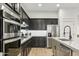 Stylish kitchen featuring modern appliances, dark cabinets, and bright countertops at 40614 N Harbour Town Ct, Anthem, AZ 85086