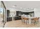 Spacious kitchen featuring dark cabinets, stainless steel appliances, large island with seating and light hardwood floors at 40614 N Harbour Town Ct, Anthem, AZ 85086