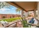 Inviting covered patio with comfortable seating and views of the landscaped backyard and greenery at 40614 N Harbour Town Ct, Anthem, AZ 85086