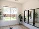 Bright room with a large window overlooking a serene backyard, complemented by stylish mirrors and plants at 40614 N Harbour Town Ct, Anthem, AZ 85086