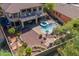 Aerial view of backyard with a sparkling pool, hot tub, covered patio, balcony, and lush landscaping at 4264 S Columbine Way, Gold Canyon, AZ 85118