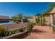 Lush backyard with a partially-covered patio, stone details, and desert landscaping with a clear blue sky above at 4264 S Columbine Way, Gold Canyon, AZ 85118