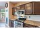 Well-equipped kitchen boasting stainless steel appliances, granite countertops, and warm brown cabinetry at 4264 S Columbine Way, Gold Canyon, AZ 85118