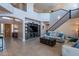Spacious living room with a two-story ceiling, a staircase, and tan tile flooring at 4264 S Columbine Way, Gold Canyon, AZ 85118