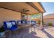 Inviting covered patio with a dining table and bright blue chairs for outdoor entertaining at 4264 S Columbine Way, Gold Canyon, AZ 85118