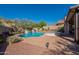 Inviting pool and spa with brick surround, rock landscaping, and waterfall features in this well-maintained backyard at 4264 S Columbine Way, Gold Canyon, AZ 85118